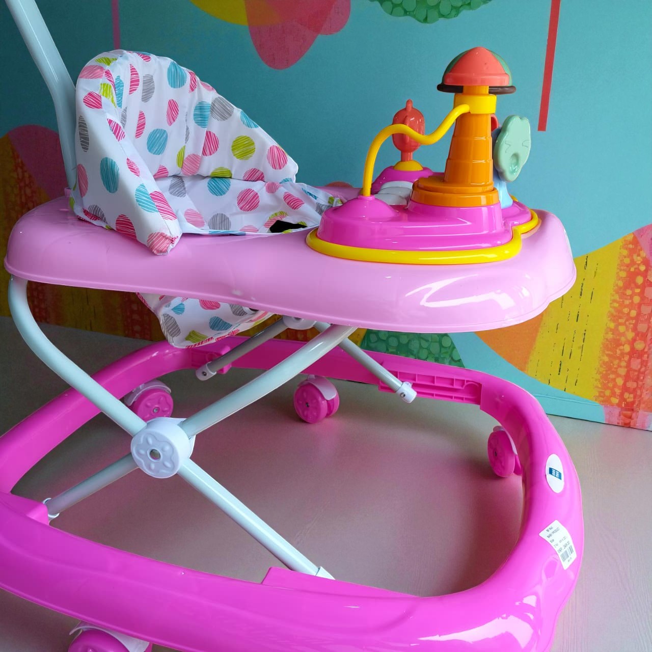 "Vibrant pink MeeMee Baby Walker with an interactive toy tray and adjustable push handle, perfect for babies 9+ months learning to walk and supporting early mobility. Usmile Toys."