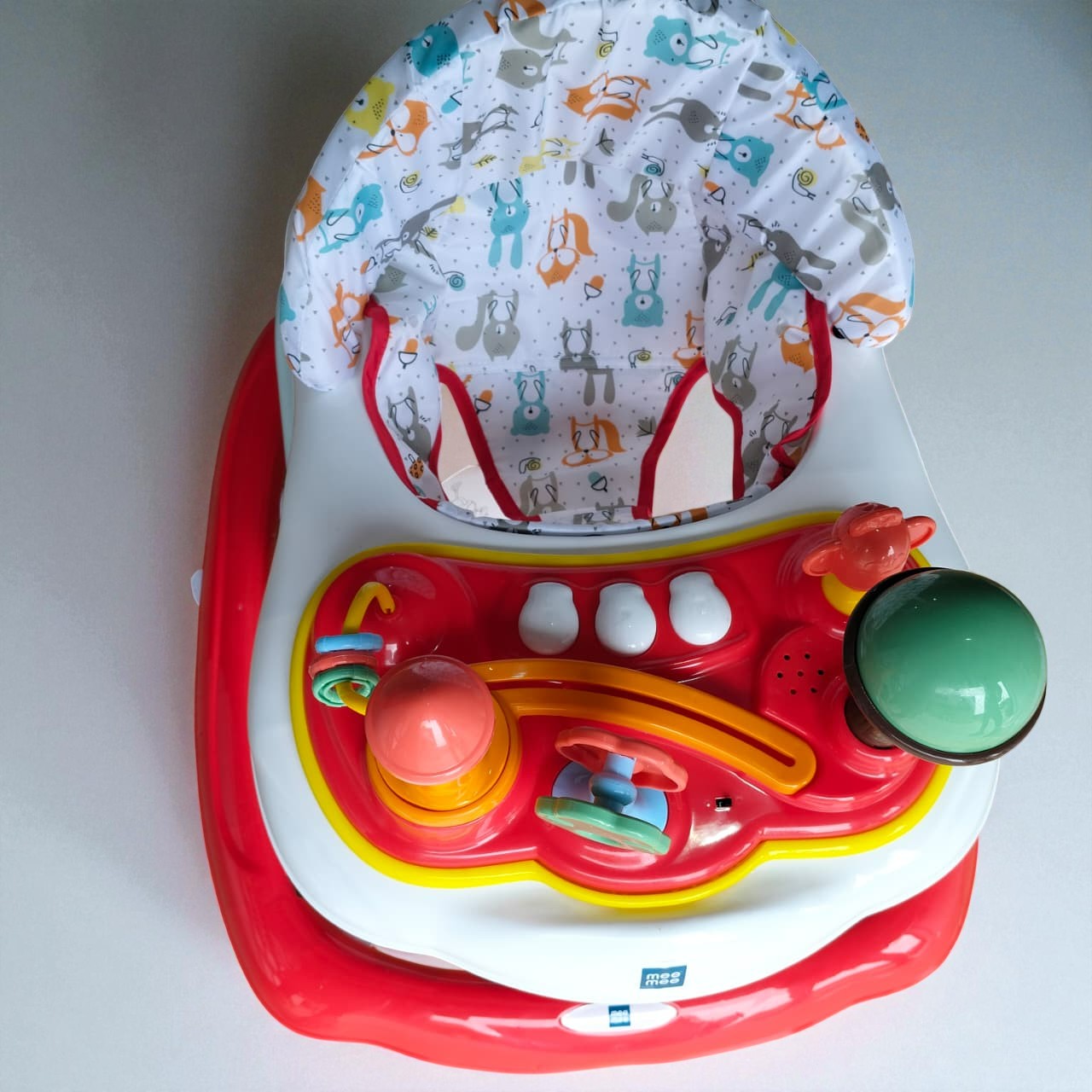 "Vibrant red MeeMee Baby Walker with an interactive toy tray and adjustable push handle, perfect for babies 9+ months learning to walk and supporting early mobility. Usmile Toys."