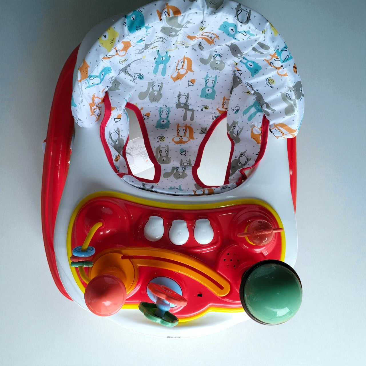 "Vibrant red MeeMee Baby Walker with an interactive toy tray and adjustable push handle, perfect for babies 9+ months learning to walk and supporting early mobility. Usmile Toys."