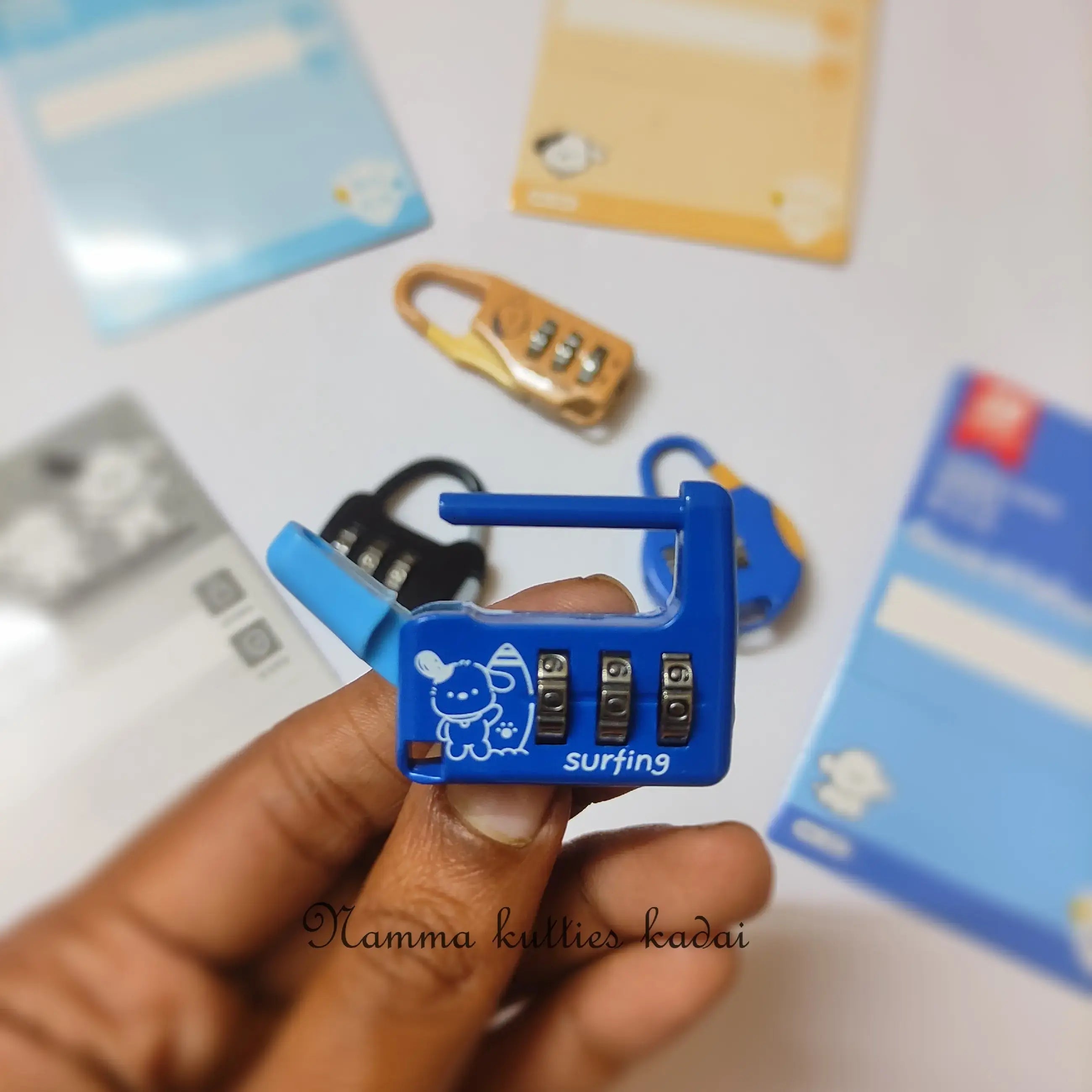 Blue combination lock held by a hand with blurred cards in the background