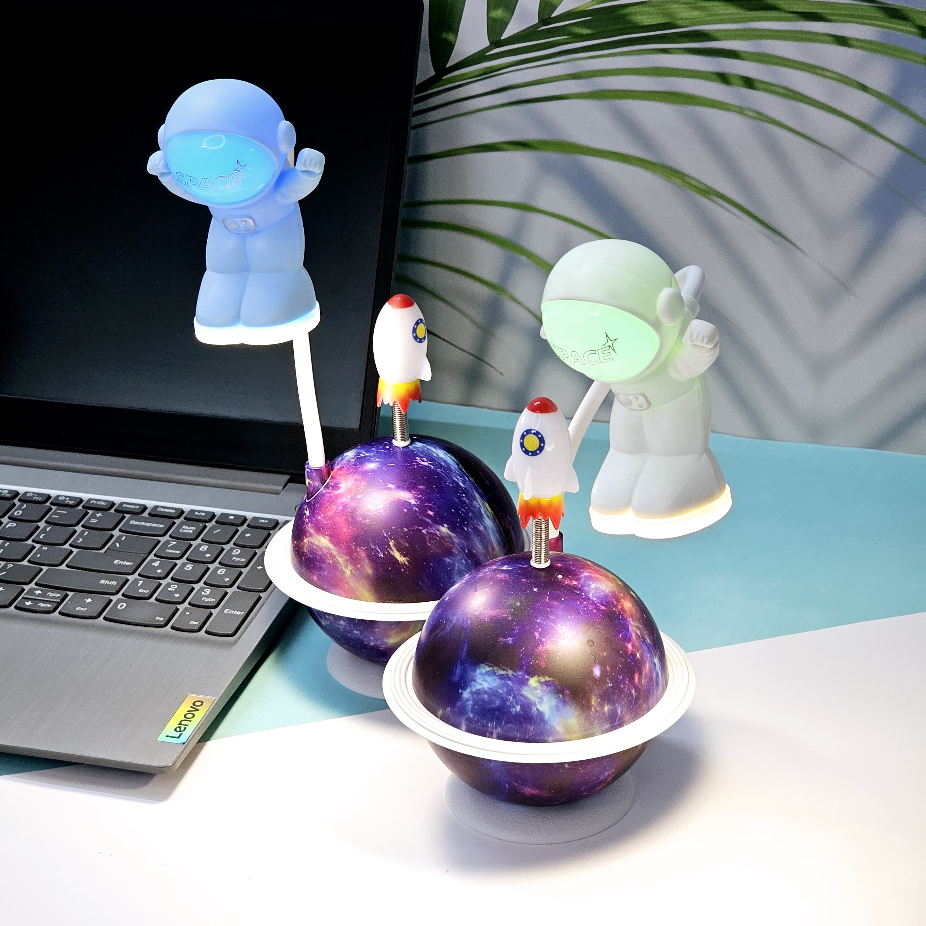 "Close-up of a Usmile Toys creative astronaut lamp, showing its white astronaut figure, flexible arm, and a striking purple and blue glowing planet base with a rocket fin."