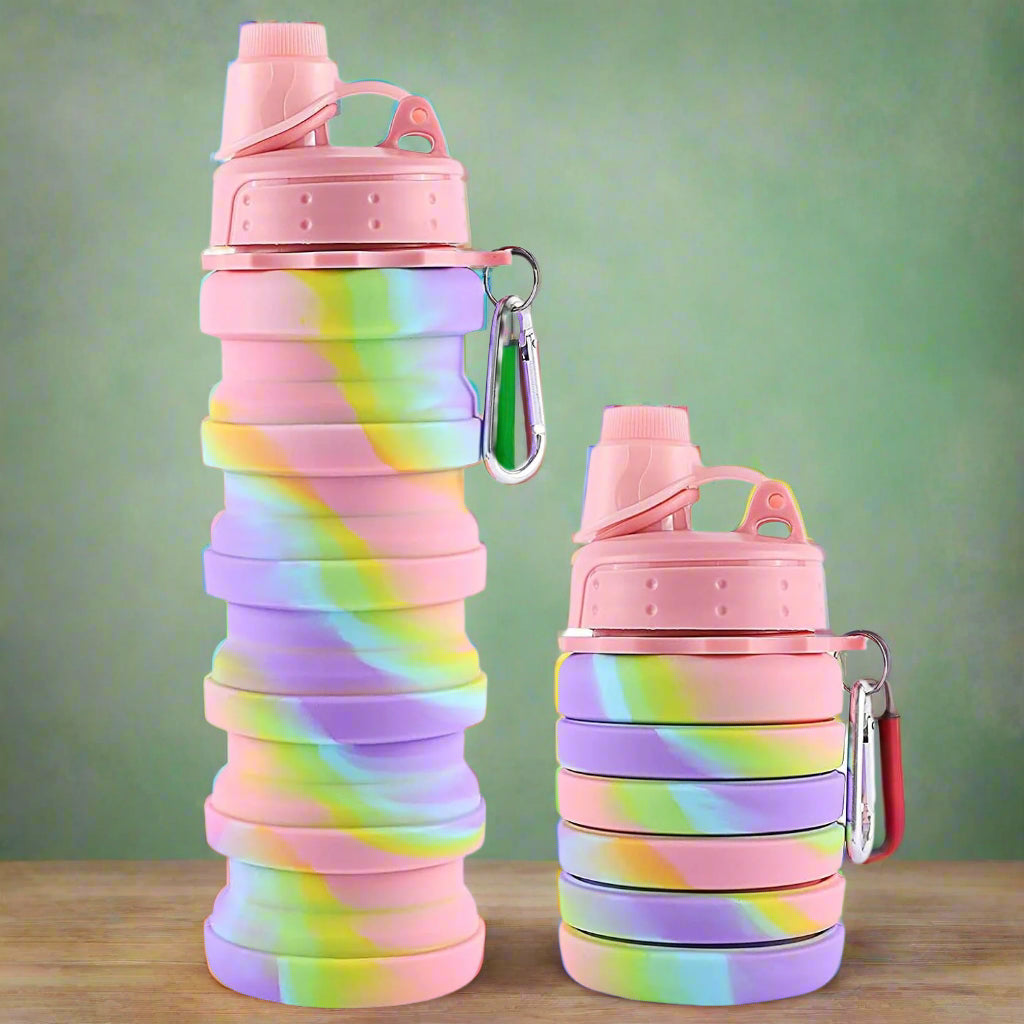 Collapsible rainbow-colored silicone water bottles for kids and adults, with secure lids and metal clips for travel. www.usmile.toys