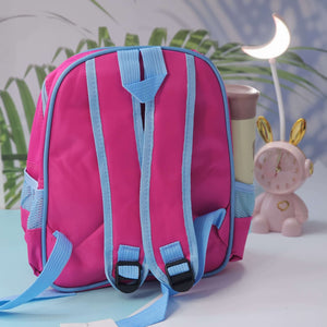 Pink backpack with blue straps on a light blue surface with decorative items in the background