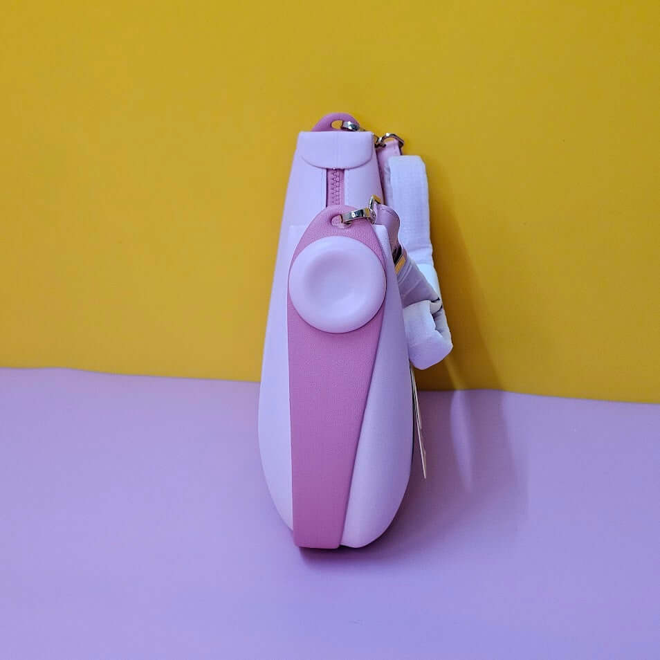 Pink and white pouch with a small round mirror on a yellow and purple gradient background