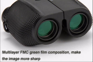 Black binoculars with green lenses on a white background