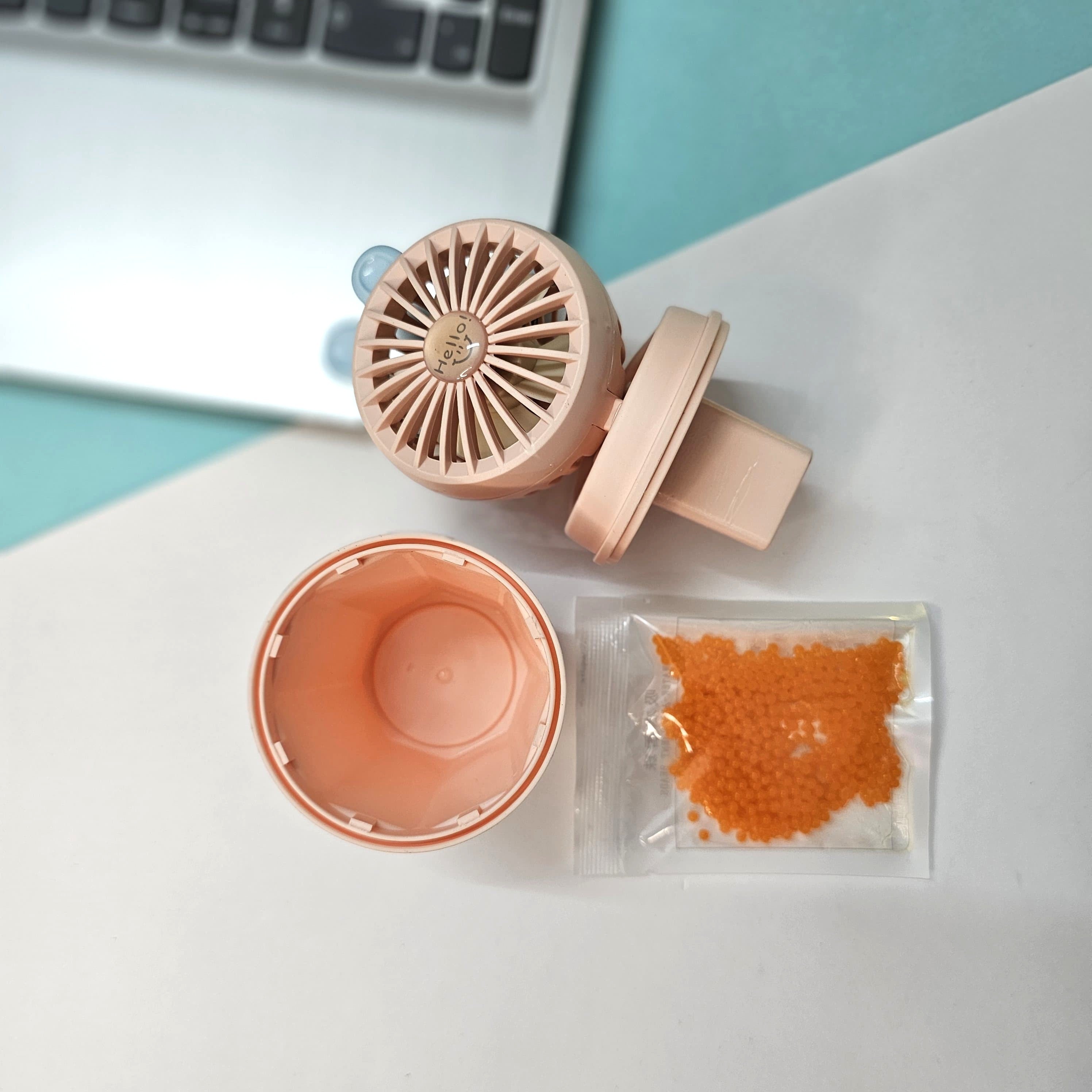 Pair of Usmile Toys hi-speed kids desk fans in light blue and pink, each featuring cute bunny ears and a 'hello' design on the grille, ideal for a child's personal space." www.usmile.toys