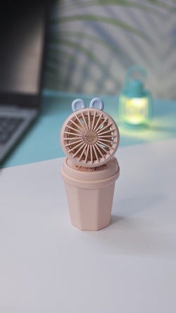 Front view of two Usmile Toys Hi Speed Kids Desk Fans, a blue and a pink one, showing their round grilles with a 'hello' emoji and charming bunny ears, suitable for adding a breeze and fun to any desk."