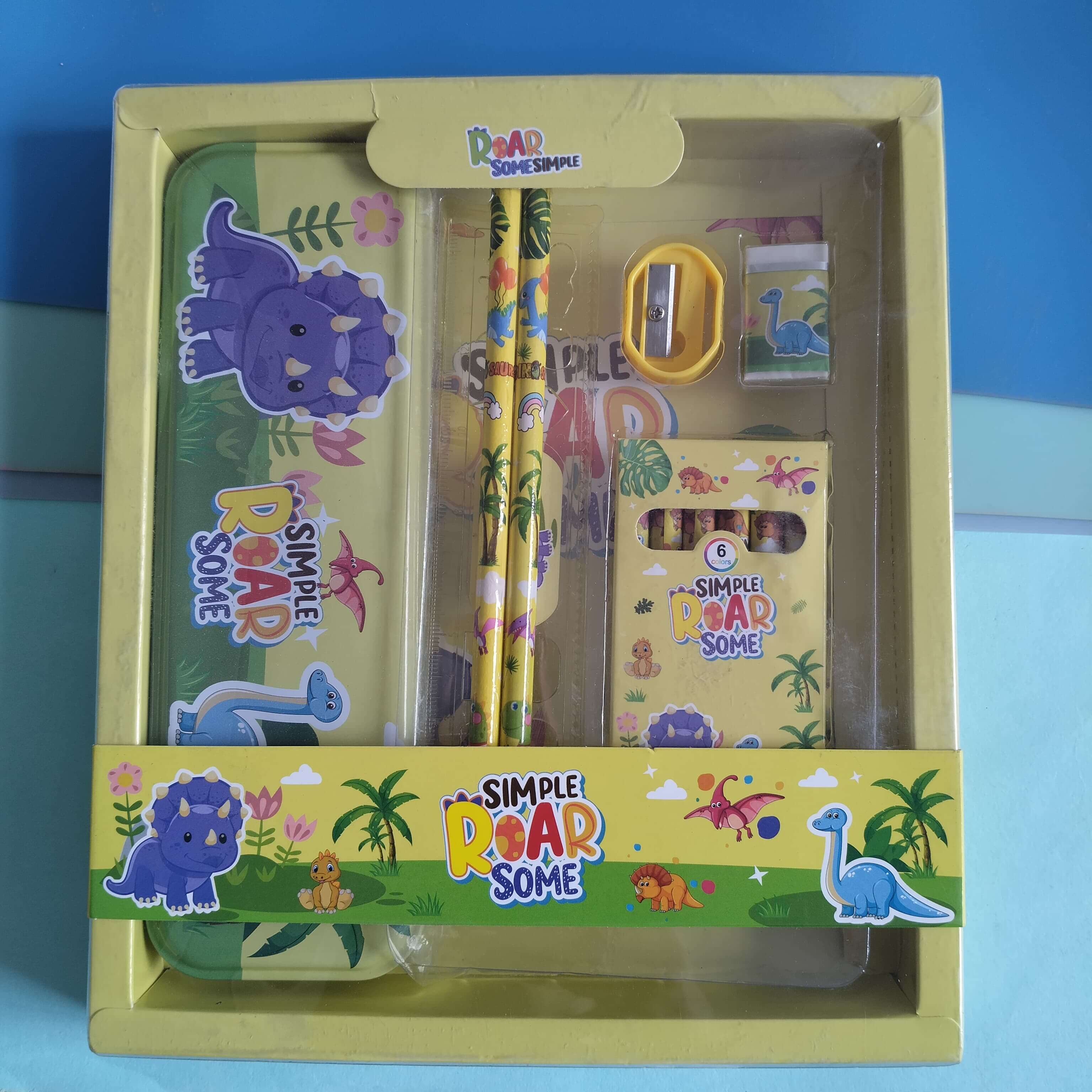 Children's stationery set with dinosaur design in a yellow box on a blue background