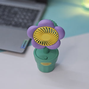Usmile Toys 'Mini Desk Fan for Kids': an adorable flower-designed fan in yellow, purple, and pink, providing a gentle breeze as a cute desktop accessory."www.usmile.toys