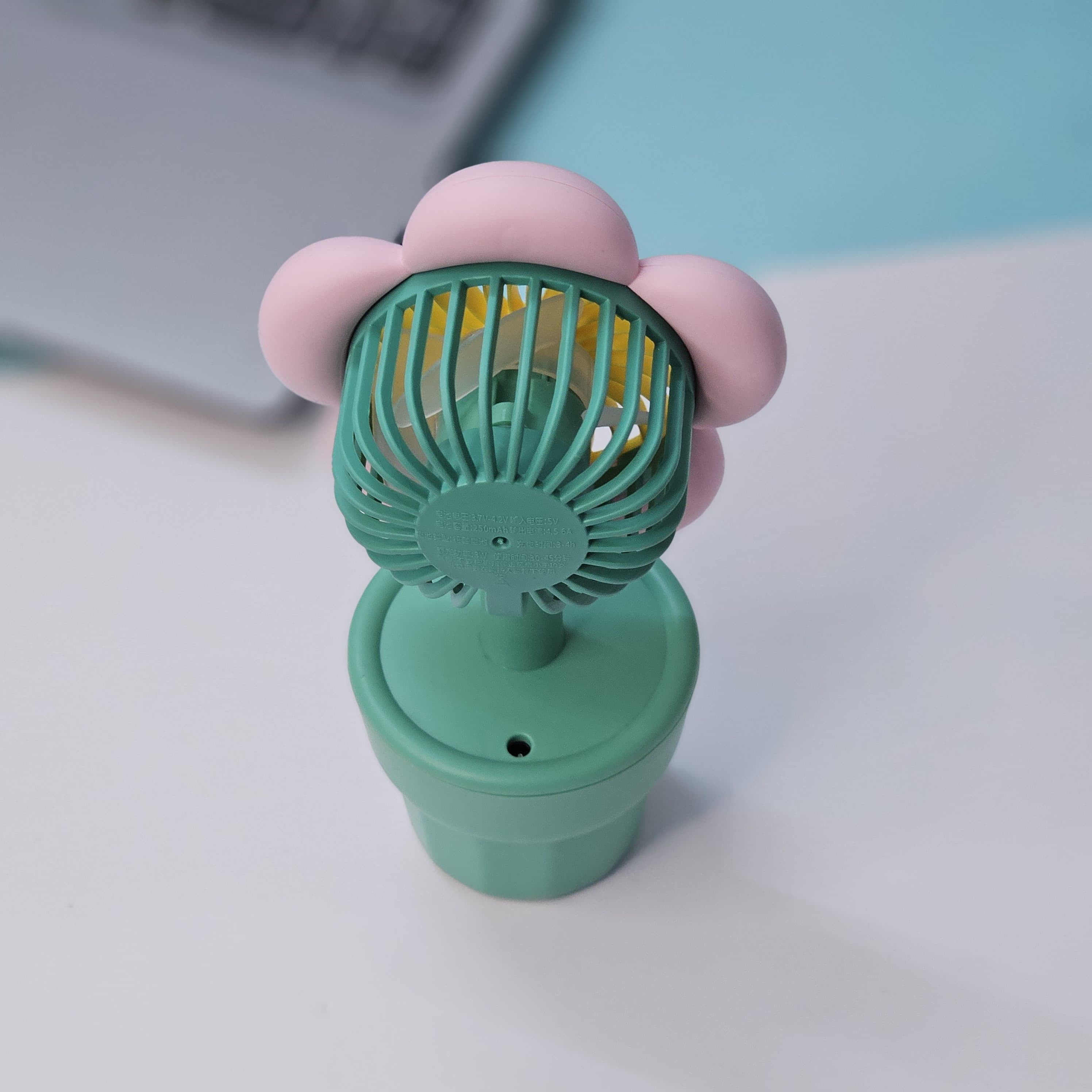 Usmile Toys 'Mini Desk Fan for Kids': an adorable flower-designed fan in yellow, purple, and pink, providing a gentle breeze as a cute desktop accessory."www.usmile.toys