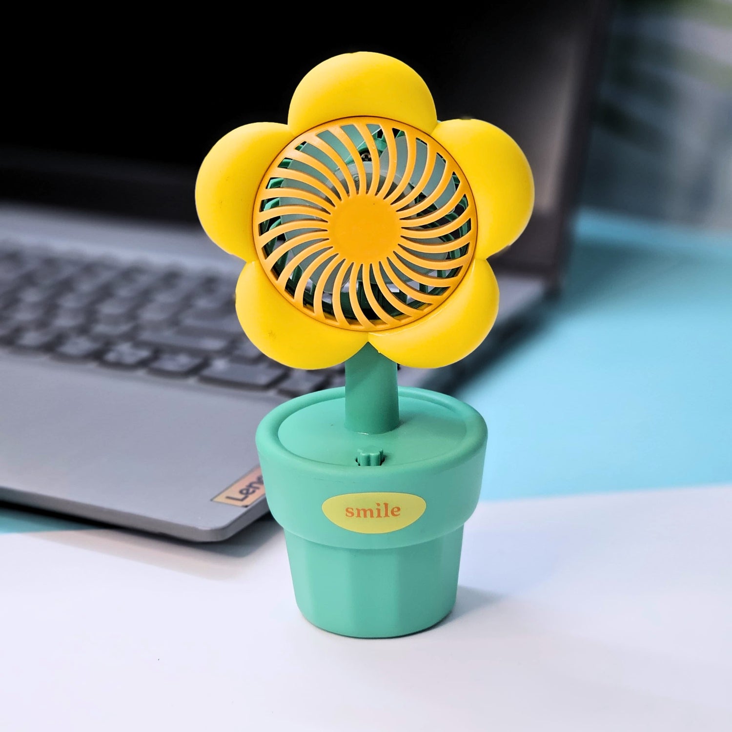 Front view of three Usmile Toys flower-shaped portable fans, featuring colorful petals and a 'smile' engraved green pot base, ideal for children. www.usmile.toys