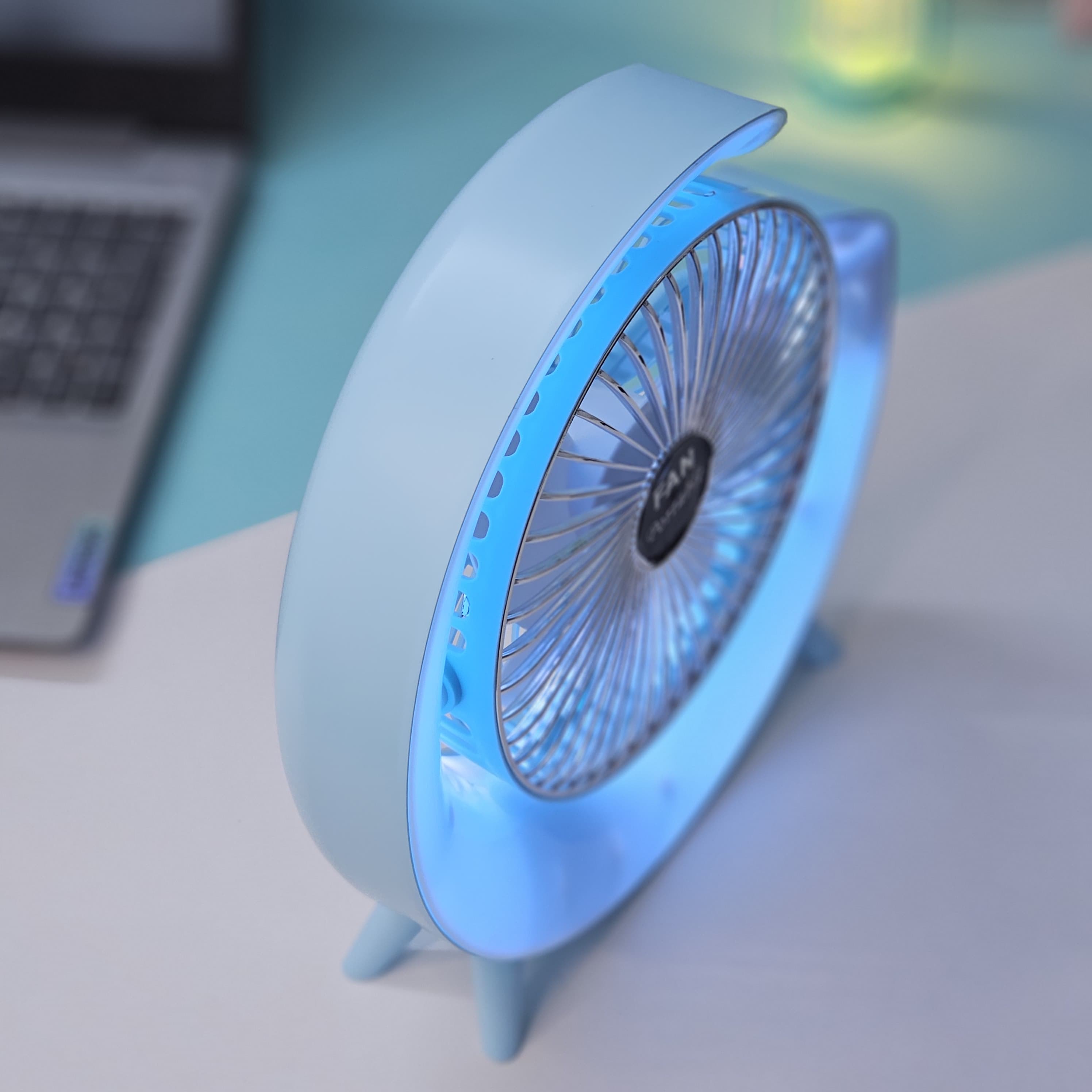 Light blue Usmile Toys moon-shaped high-speed desk fan, featuring a captivating blue LED glow, designed for efficient personal cooling on desktops." www.usmile,toys