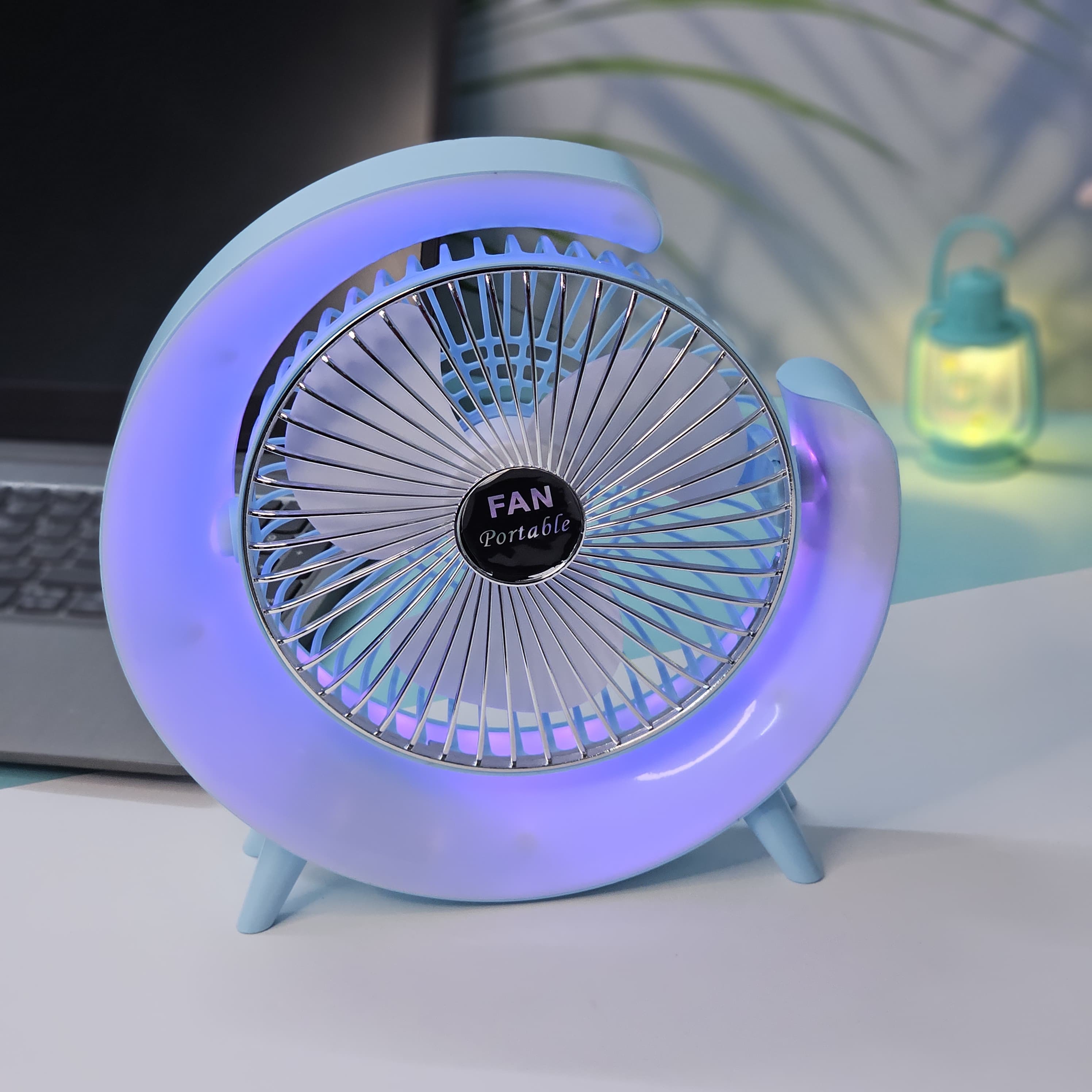 Close-up of a Usmile Toys unique desk fan, showing its light blue curved design, fan blades, and the soft blue illumination from its integrated LED lights."