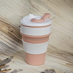 Pink and white 300ml pocket-size silicone travel coffee cup with a ridged grip and attached drinking spout cover. www.usmile.toys
