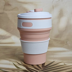 Pink and white 300ml pocket-size silicone travel coffee cup with a ridged grip and attached drinking spout cover. www.usmile.toys