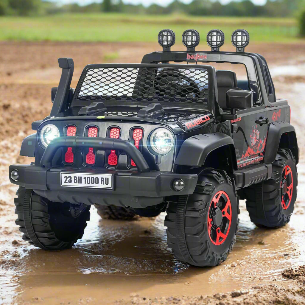 Black battery operated kids jeep ride-on car with red accents, features Bluetooth, music, and working lights, driving through mud. www.usmile.toys