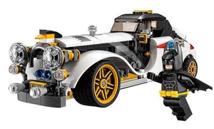 Lego-style building block set featuring a white classic car with gold wheels, Batman minifigure flying above, and Batarang accessory. Perfect for kids to assemble superhero adventures. www.usmile.toys