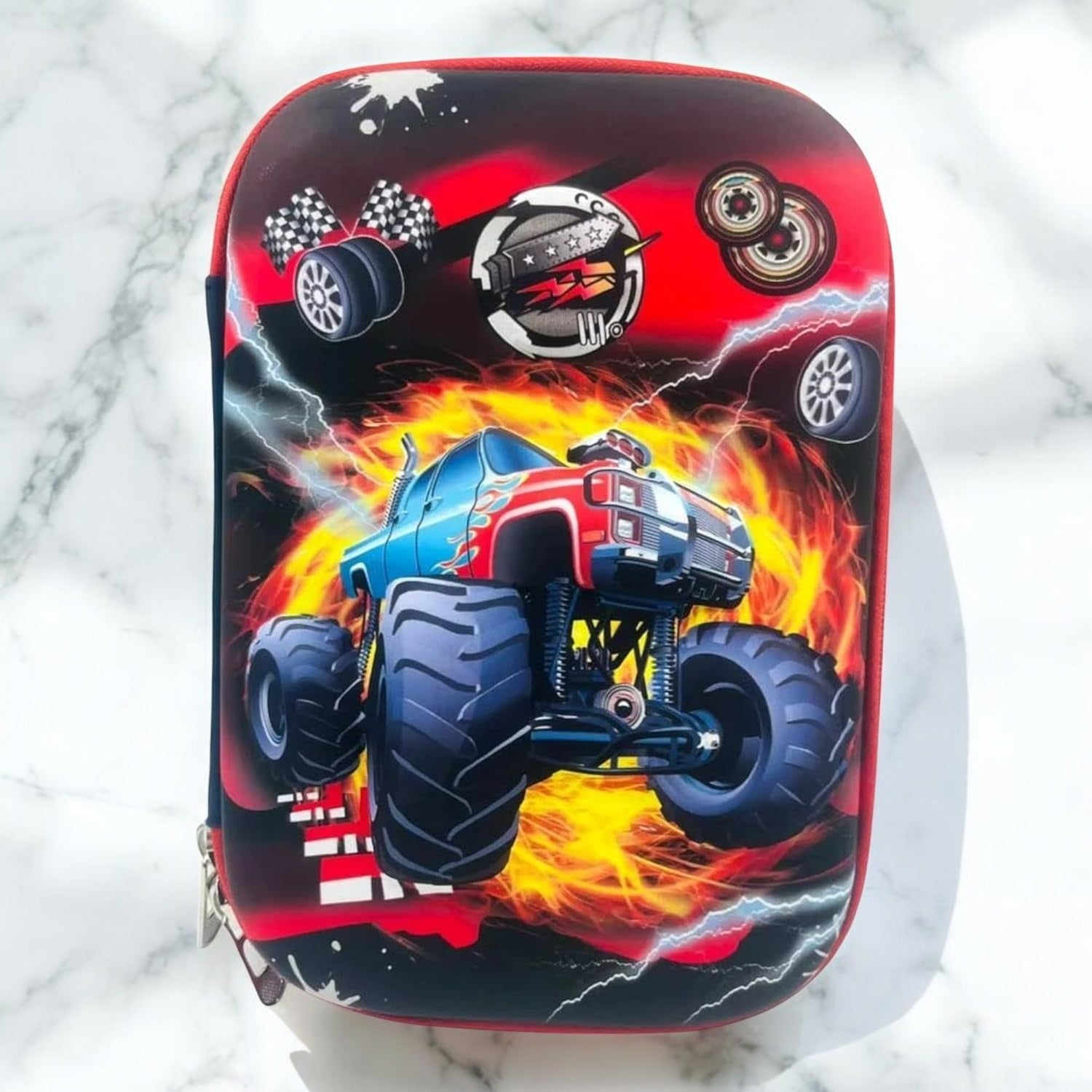 Red and black silicone pencil case for boys with a prominent 3D monster truck print engulfed in flames and lightning, featuring wheels and engine designs. Ideal for school stationery from uSmile.toys.