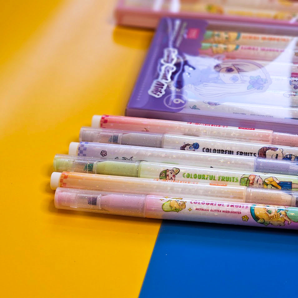 Set of 6 colorful metallic glitter highlighter pens for kids, packaged in two pastel-themed boxes labeled “Fruity Sweet Mix.” Each pen features cute cartoon character prints and soft, vibrant ink colors perfect for journaling, school projects, or creative doodling. The packaging is designed with anime-style illustrations of girls in whimsical outfits, appealing to children and stationery lovers. Displayed on a dual-tone yellow and blue background, this pen set makes a fun and eye-catching gift for birthdays