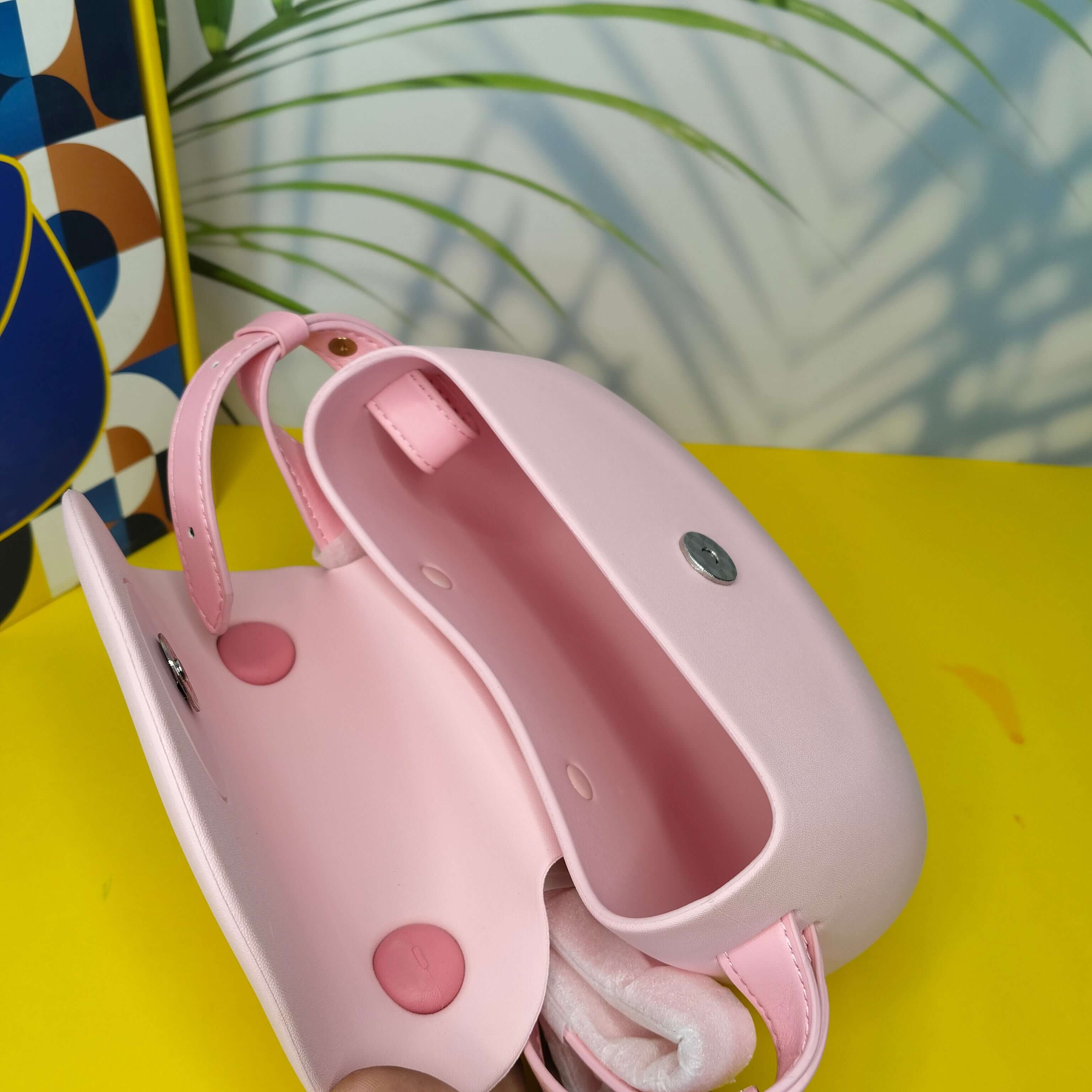 Pink and white dog muzzle on a yellow surface with a colorful abstract pattern in the background