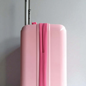 Pink suitcase with a silver handle on a gray background
