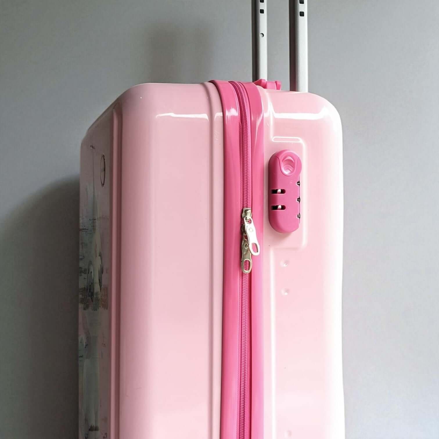 Pink suitcase with a visible zipper on a gray background