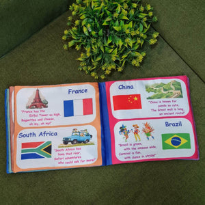 "Flag of the World" fabric book by Kidogen, displaying pages about India, USA, Italy, and the United Kingdom with their flags, landmarks, and descriptive rhymes.
