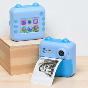 Children's HD Digital Print Camera FS14 in light blue, featuring instant photo printing. The image shows the camera alongside its retail box, ideal for young photographers. www.usmile.toys