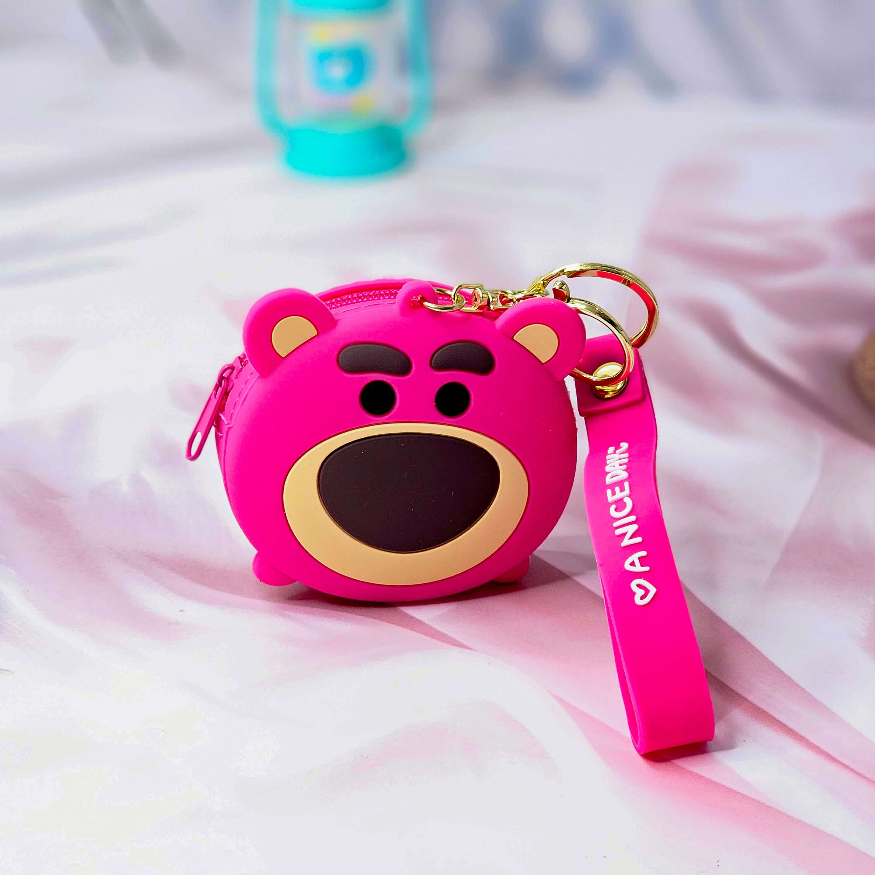 Cute Tom cartoon character silicone coin purse and keychain, featuring green eyes, a wide smile, and a grey wrist strap with "A NICE DAY :)" text. This fun and practical accessory is perfect for kids and fans of cartoon characters, ideal for holding coins or small items. www.usmile.com