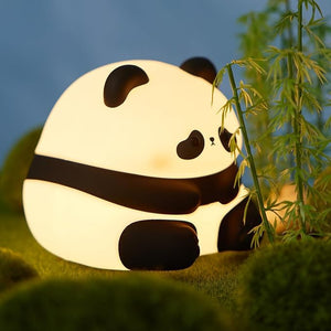 Adorable glowing white and black silicone night lamp for kids, shaped like a baby sitting panda with a sweet expression. Provides a soft, comforting light for bedrooms from uSmile.toys www.usmile.toys