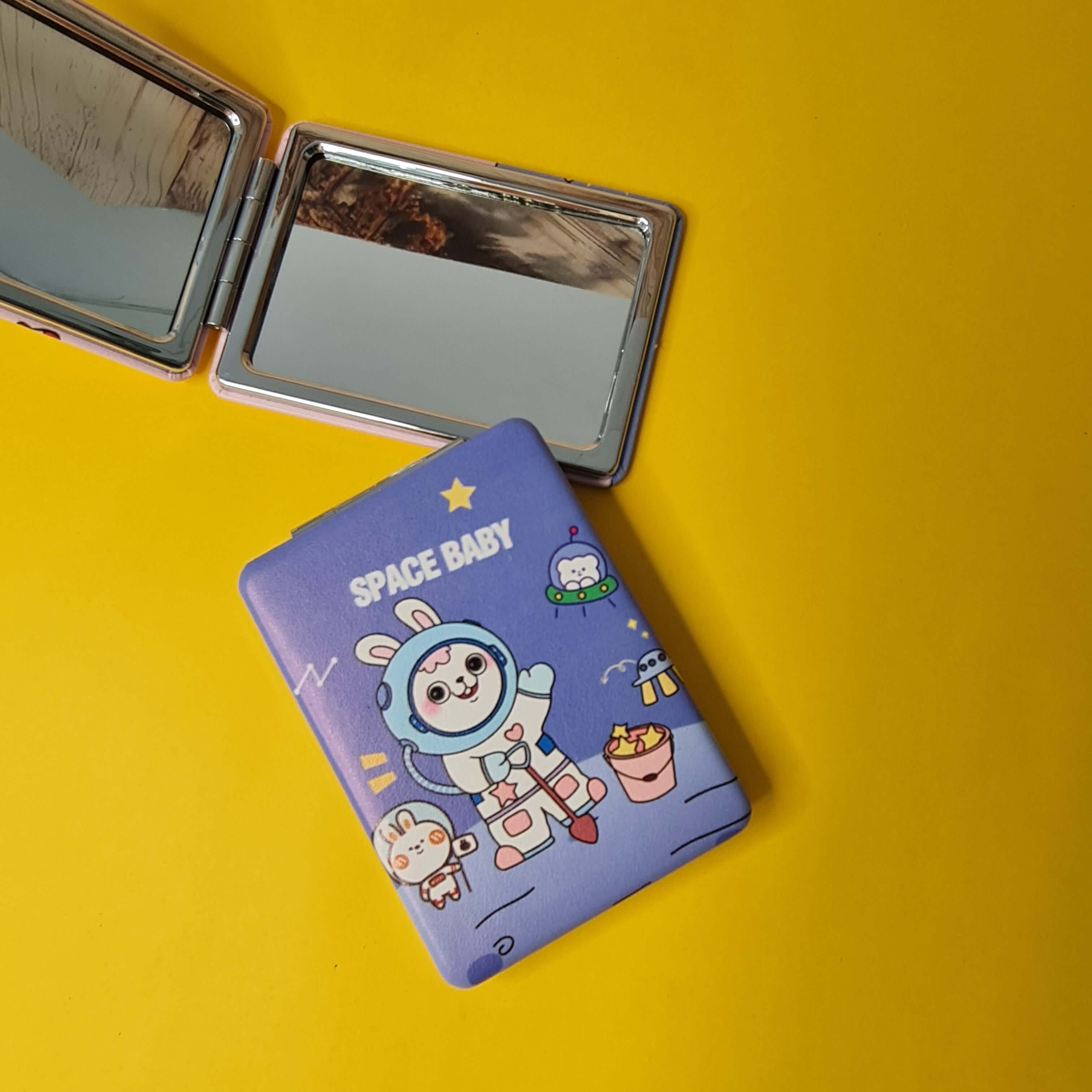Compact mirror with cartoon character design on a yellow background