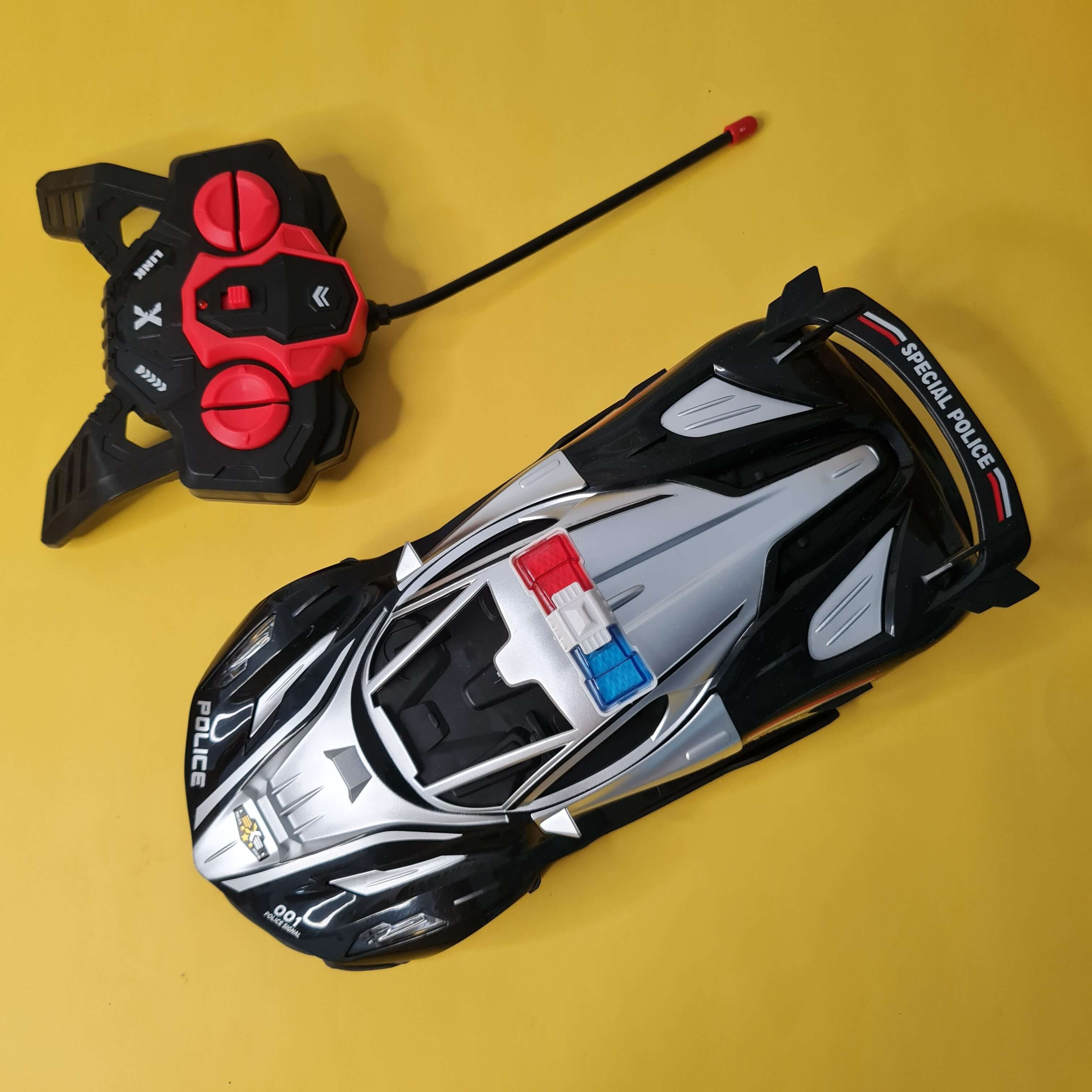 Toy police car with remote control on a yellow background