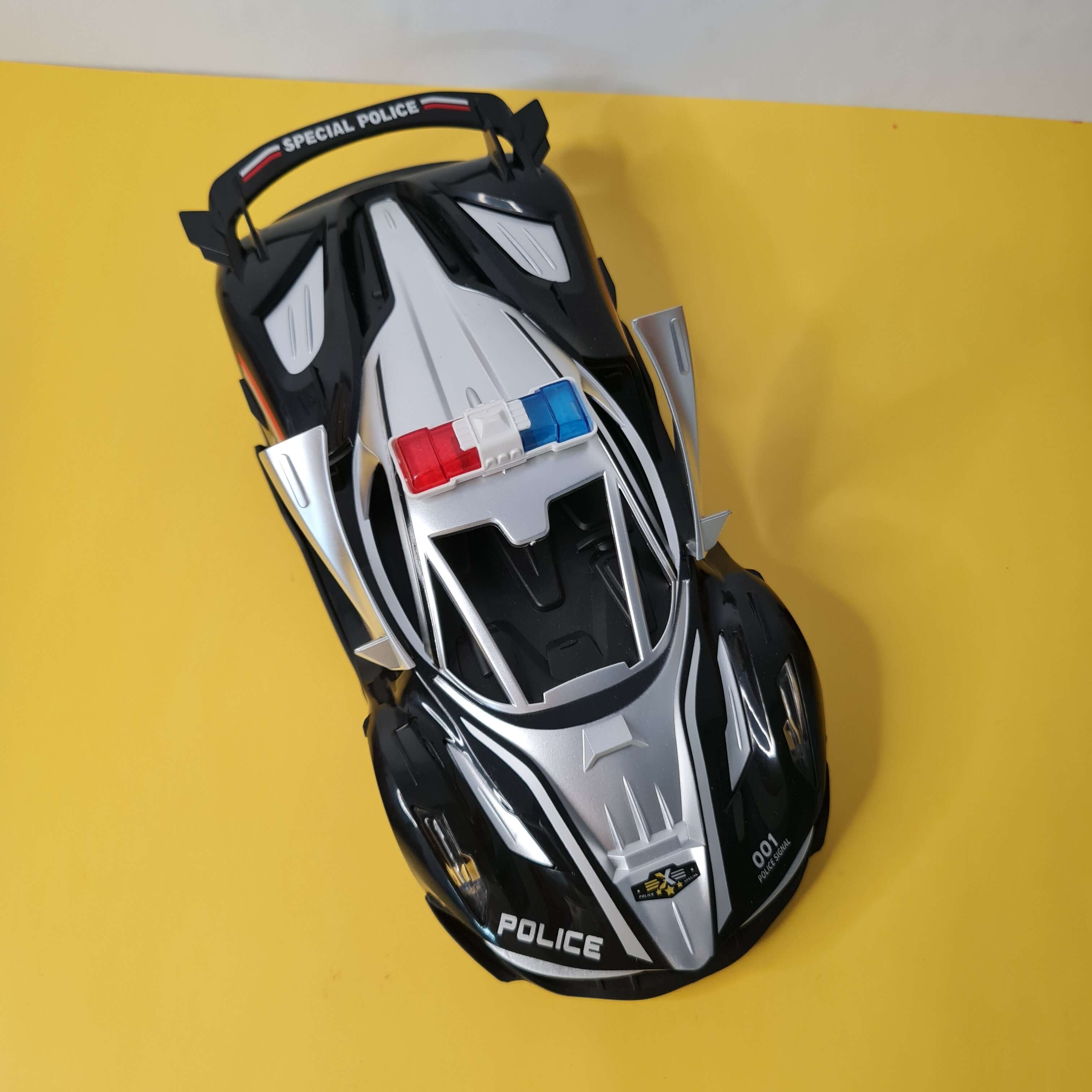 Toy police car on a yellow background