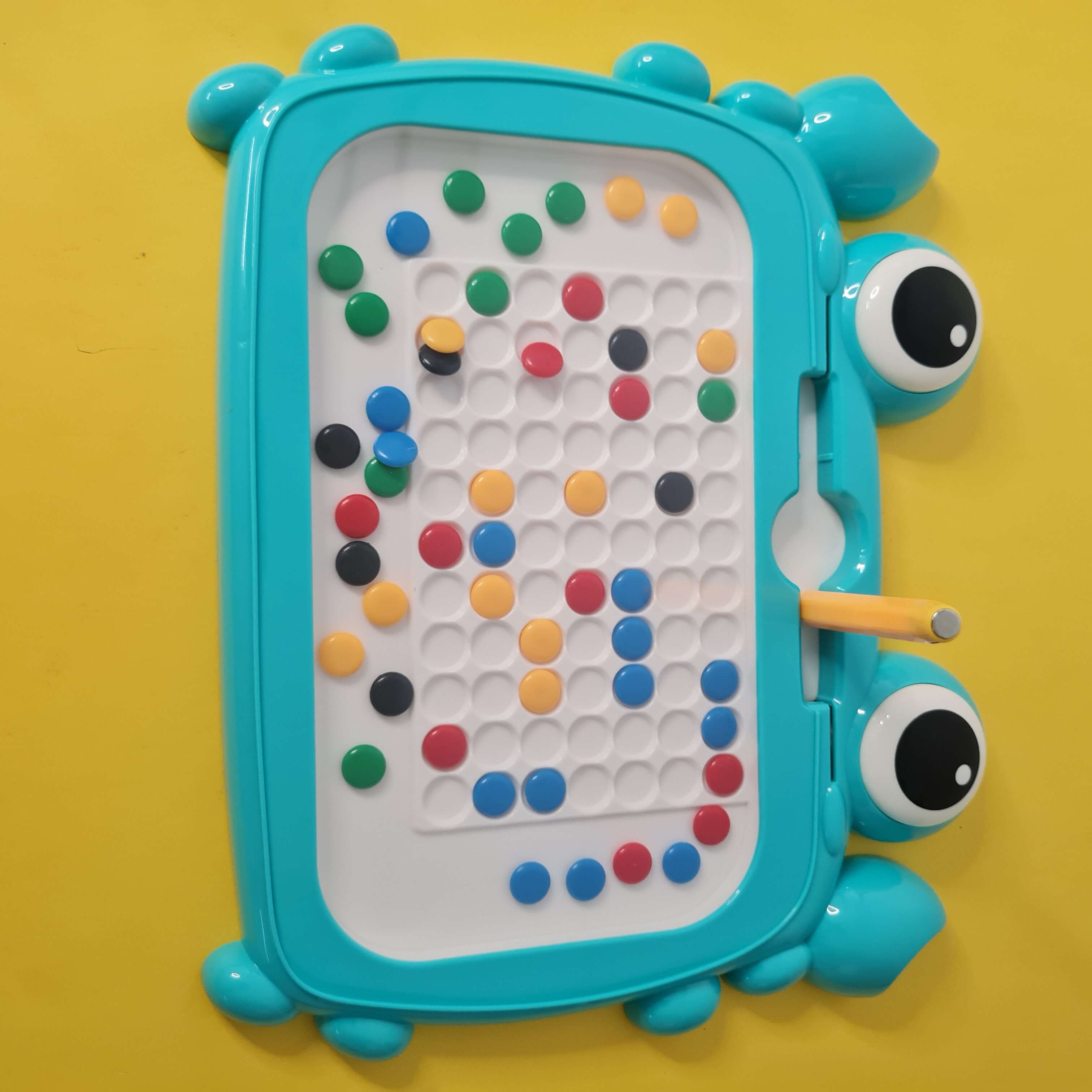 Toy with colorful beads on a yellow background