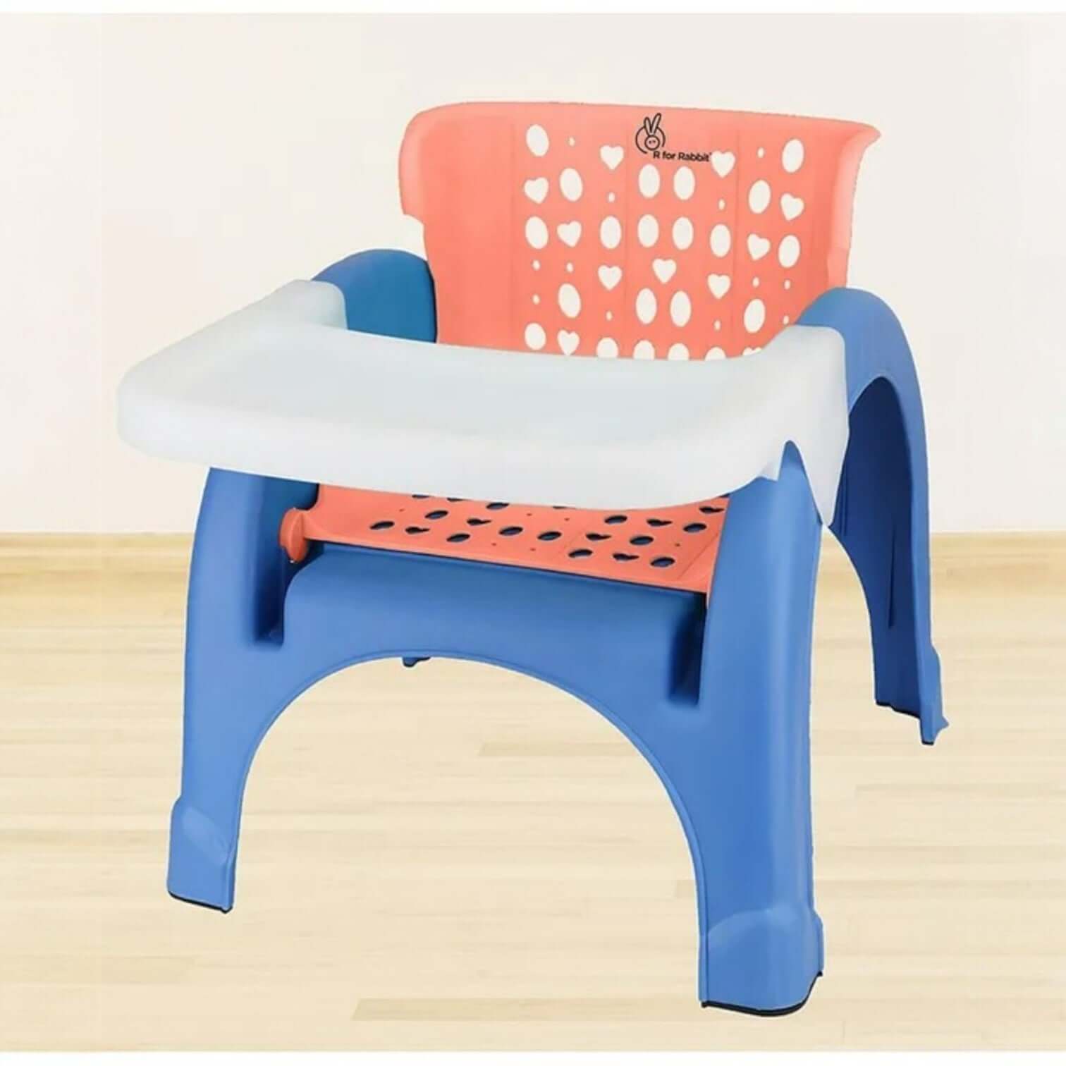 Children's plastic chair with heart-patterned backrest on a light wooden floor.