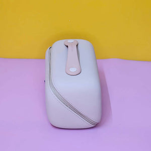 White electronic device with a pink strap on a purple surface with a yellow background