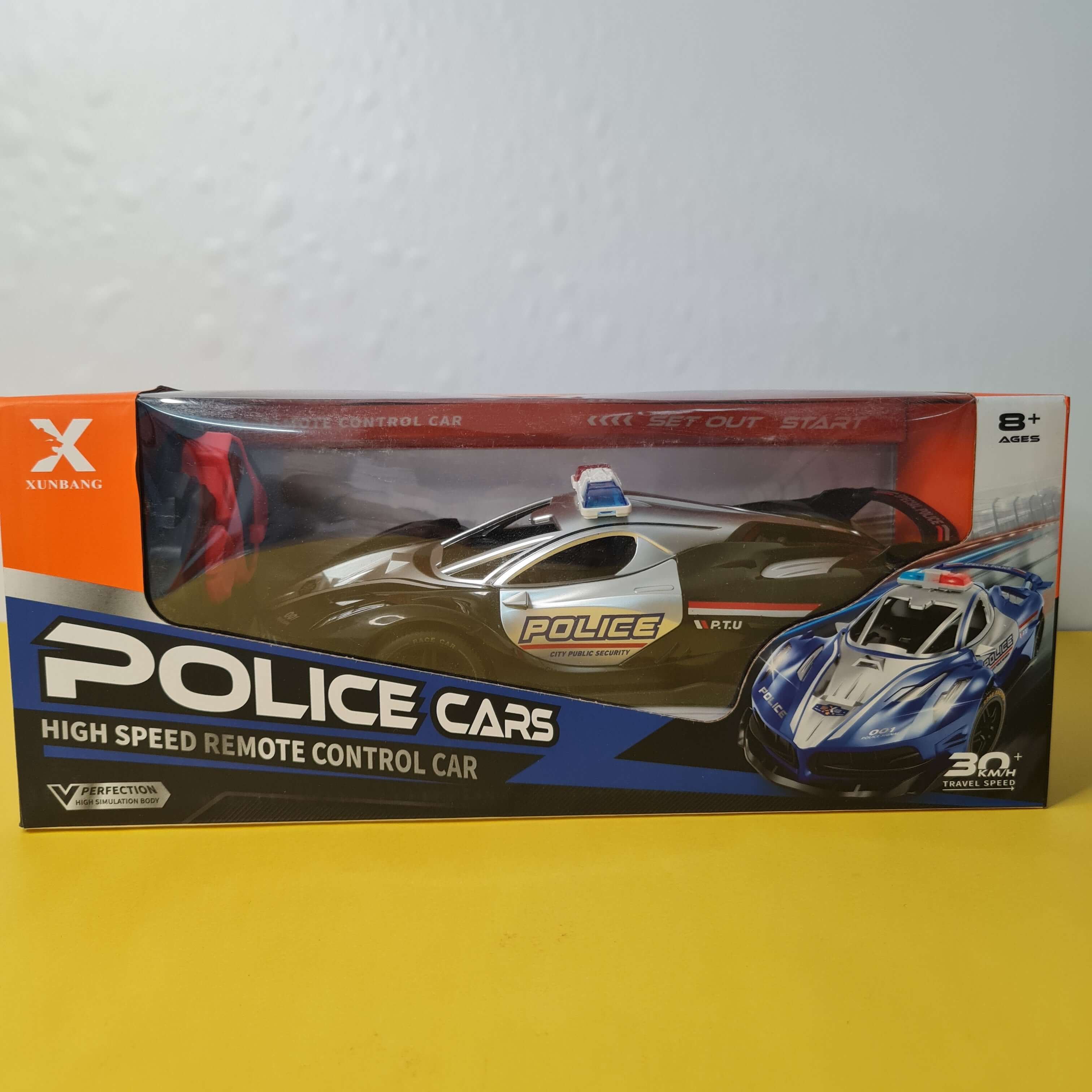 Boxed police-themed remote control car set on a white and yellow background