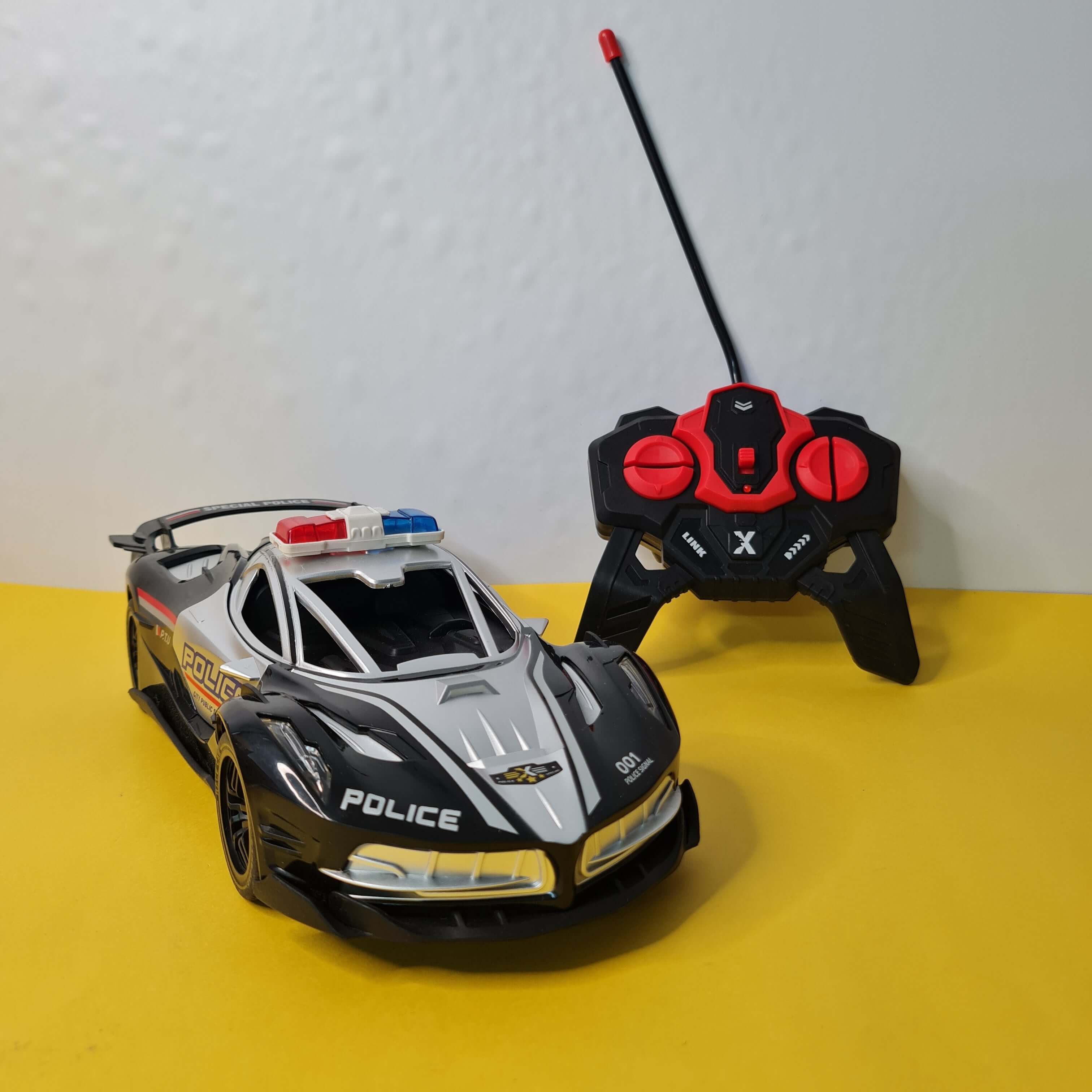 Toy police car with remote control on a yellow and white background