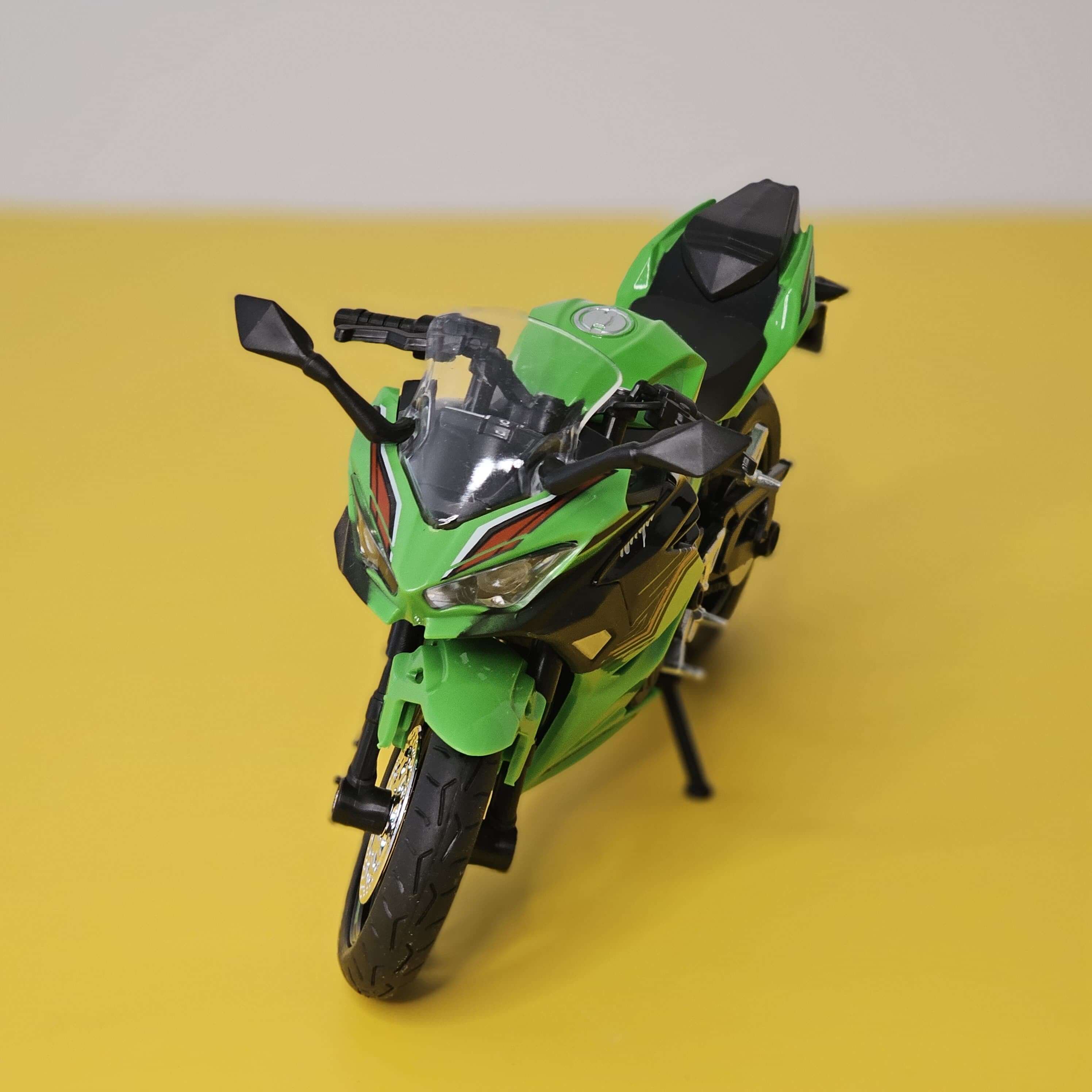 Front view of a bright green die-cast Kawasaki Ninja sports bike toy, showcasing its realistic design and working LED headlights, perfect for kids' playtime from Usmile Toys.www.usmile.toys