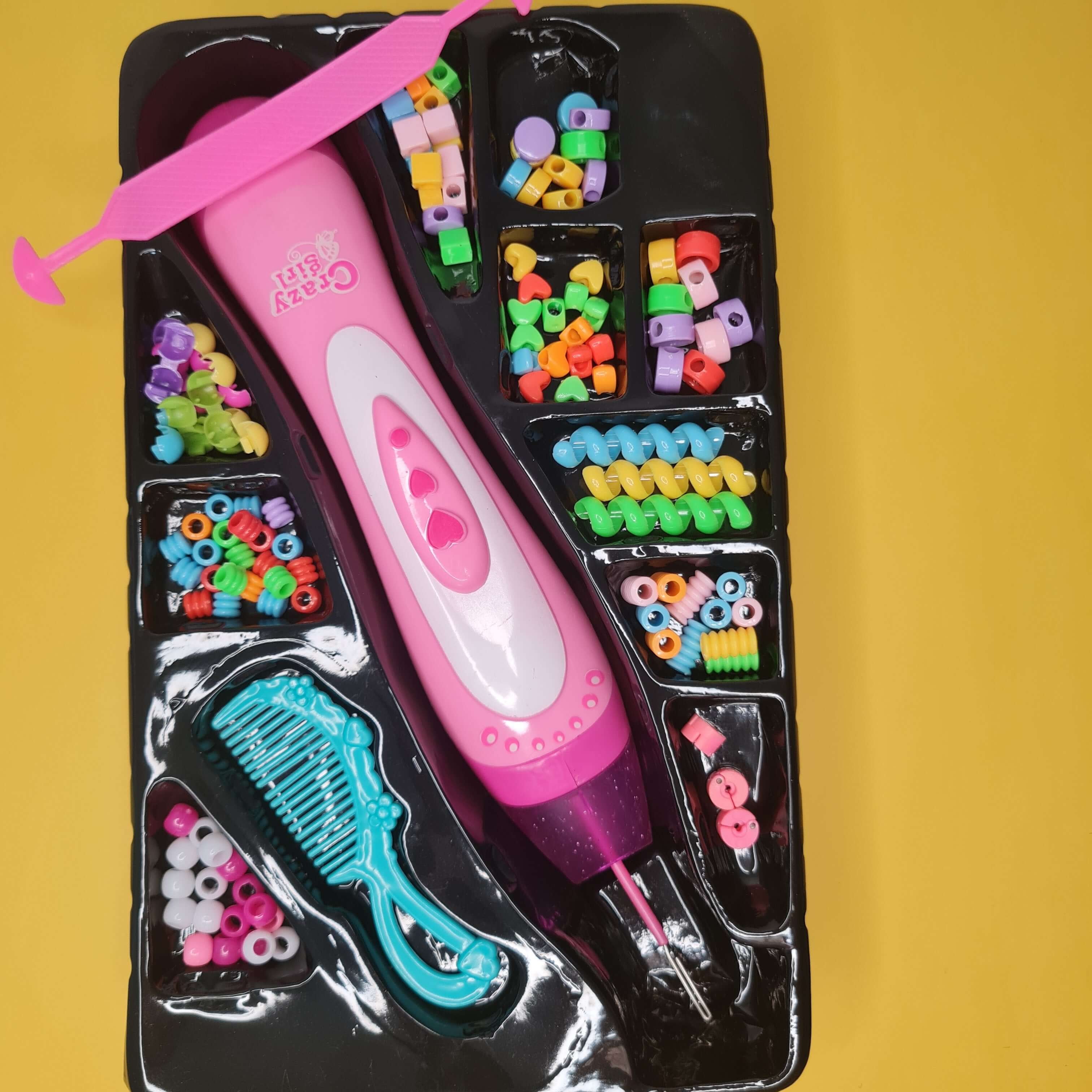 Children's hair styling toy set with colorful beads and tools on a yellow background