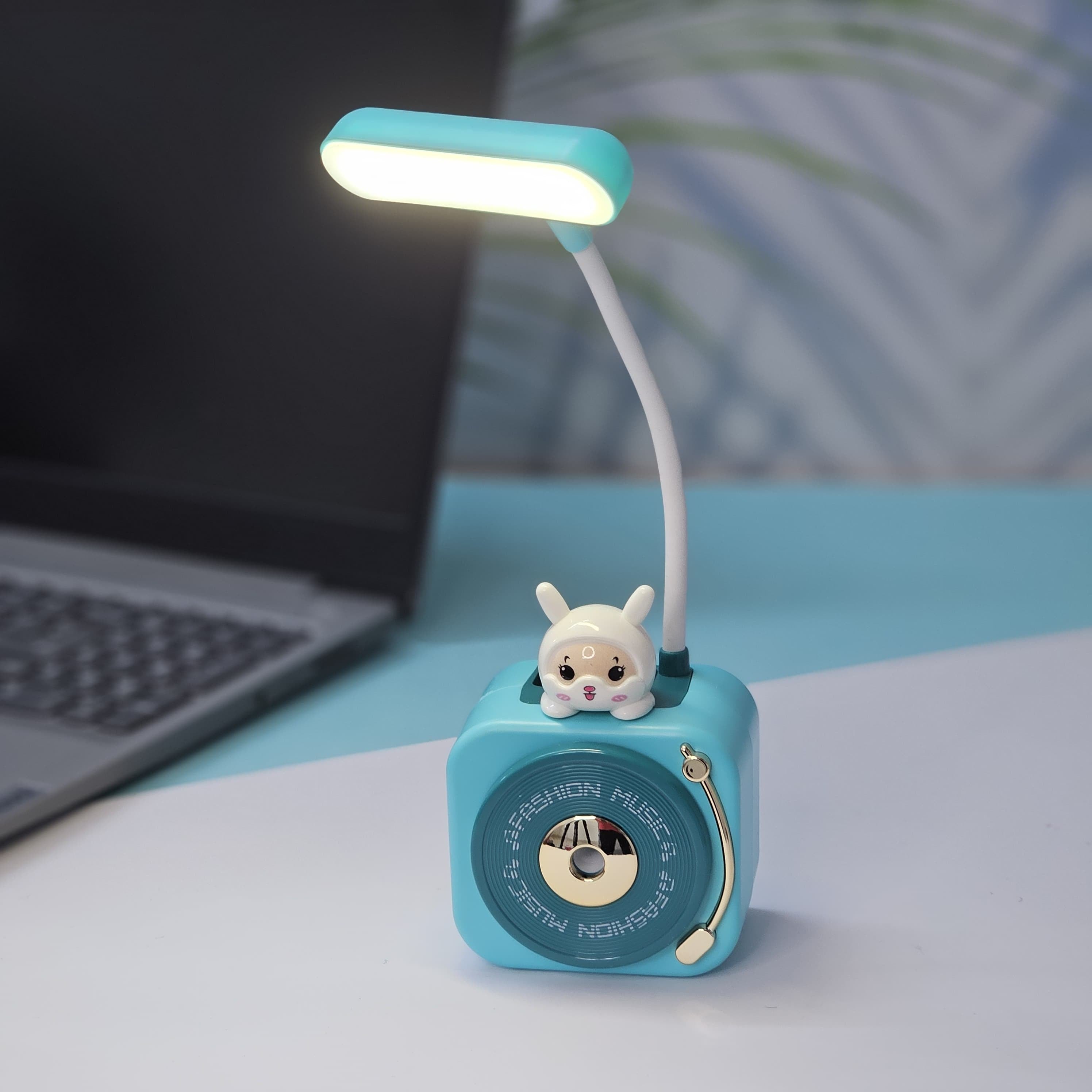 Usmile Toys 3-in-1 multi-functional LED desk lamp in a vibrant teal color, featuring a flexible gooseneck light, an integrated pencil sharpener, and a convenient pen holder with a cute little bunny charm. Ideal for kids' study desks, homework, and creative activities, promoting organization and bright illumination." www.usmile.toys
