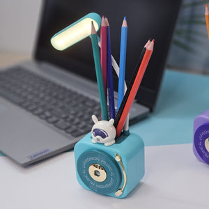 Usmile Toys 3-in-1 multi-functional LED desk lamp in a vibrant teal color, featuring a flexible gooseneck light, an integrated pencil sharpener, and a convenient pen holder with a cute little bunny charm. Ideal for kids' study desks, homework, and creative activities, promoting organization and bright illumination." www.usmile.toys