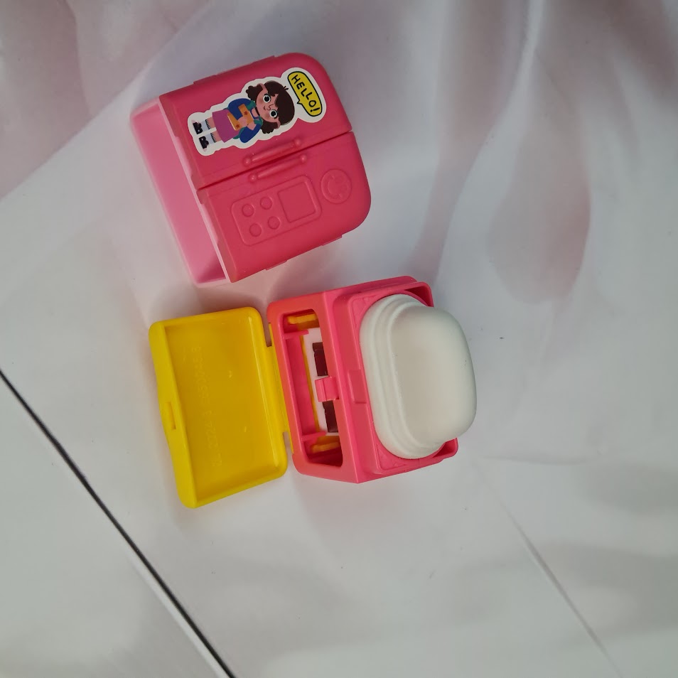 Set of four Usmile Toys adorable fridge-shaped sharpeners and erasers in pink, green, blue, and purple, each with cartoon character decals." www.usmile.toys