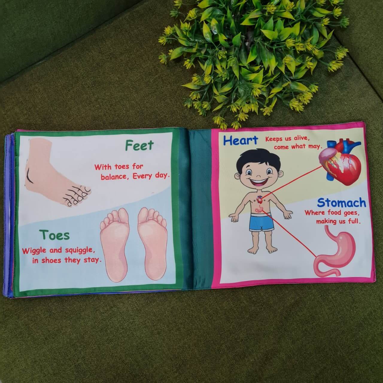 A "My Amazing Body: Head to Toe" fabric book by Kidogen, showing a cartoon child meditating with illustrations of body parts and organs around them.