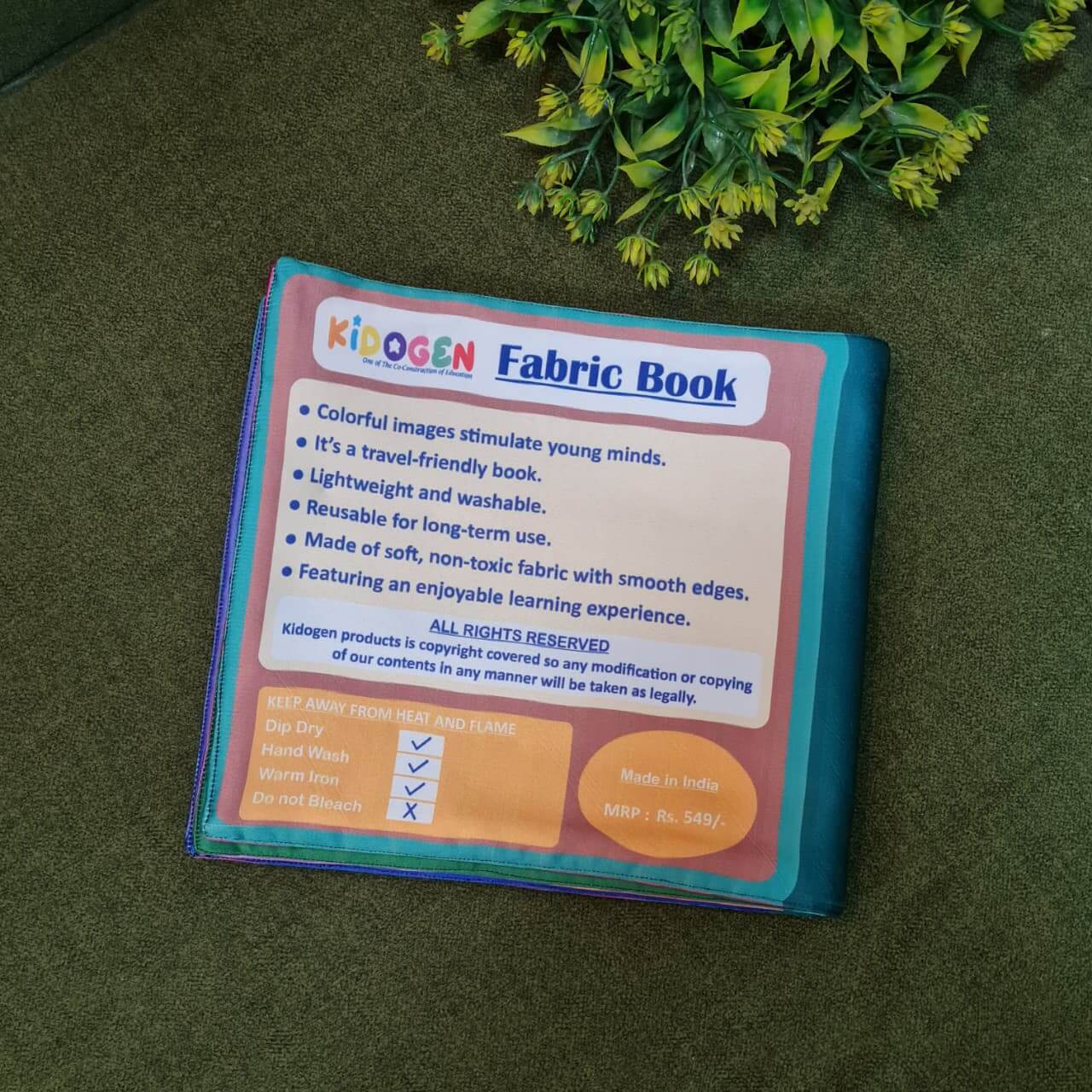 A "My Amazing Body: Head to Toe" fabric book by Kidogen, showing a cartoon child meditating with illustrations of body parts and organs around them.