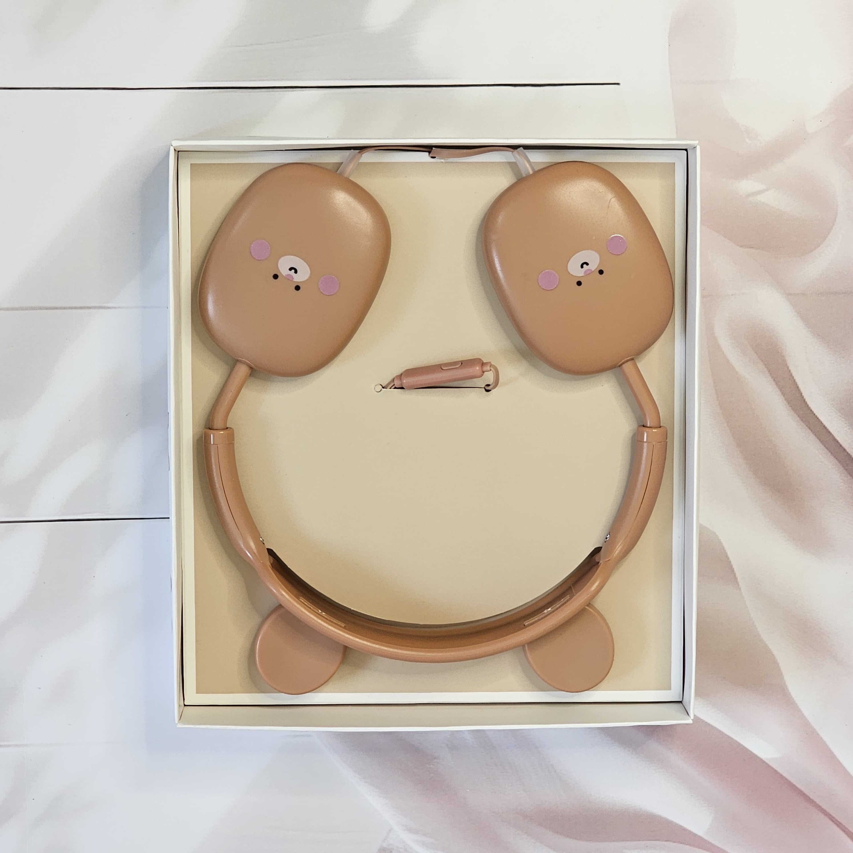 BuBu Bear wired headphones for kids, featuring a cute rabbit design in soft pink, with a detachable microphone and a visible audio jack, displayed on a white surface with floral decorations, highlighting the product's features and aesthetic appeal." www.usmile.toys