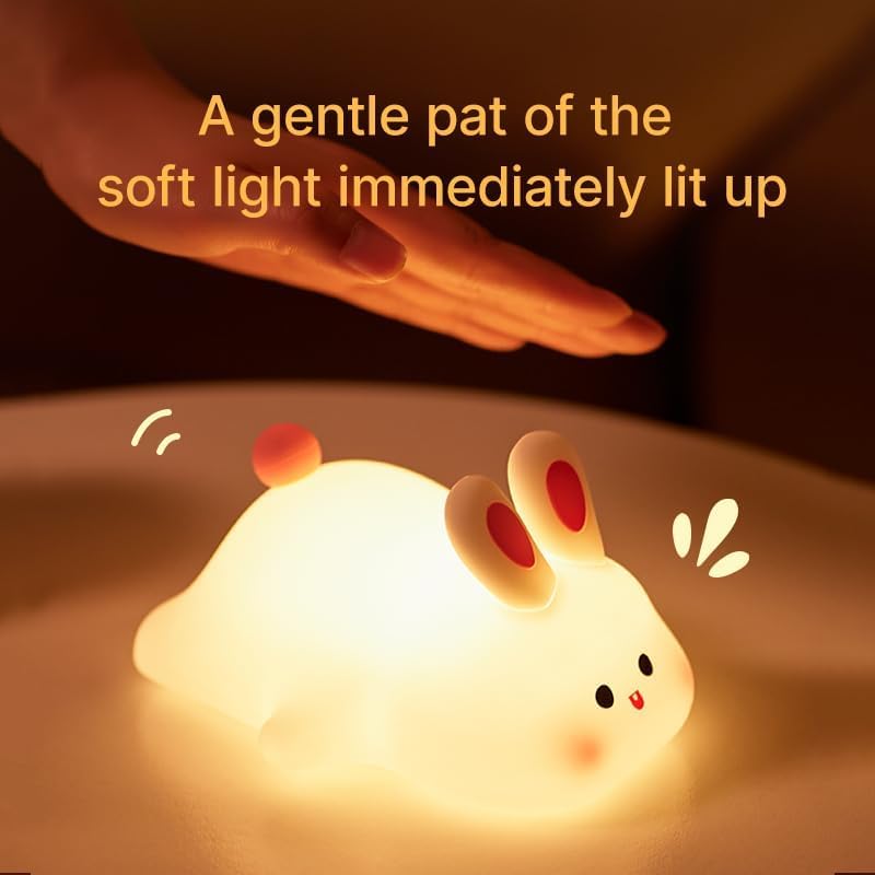 "Adorable glowing white silicone night lamp for kids, shaped like a cute rabbit with big ears and a cheerful face, being gently held. Provides a soft, comforting light for bedrooms from uSmile.toys." www.usmile.toys