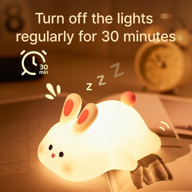 "Adorable glowing white silicone night lamp for kids, shaped like a cute rabbit with big ears and a cheerful face, being gently held. Provides a soft, comforting light for bedrooms from uSmile.toys." www.usmile.toys