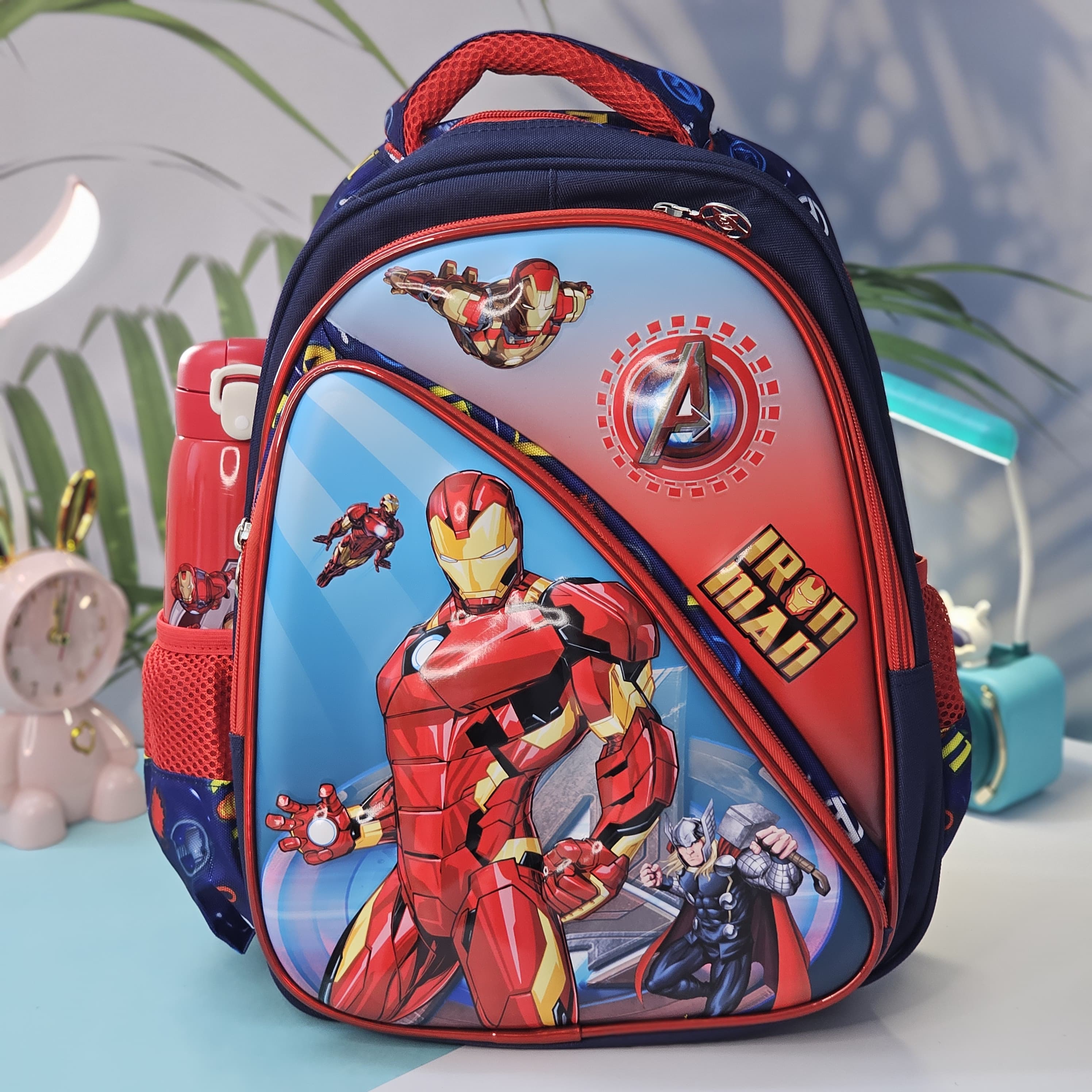 Vibrant blue children's backpack featuring large Iron Man and Thor graphics, with a red trim and side mesh pocket, perfect for kids by Usmile Toys.