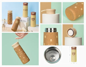 Cream-colored stainless steel insulated water bottle for kids with a brown cap, featuring a cute 'lovely bear' cartoon design. Keeps drinks hot or cold. Ideal for school or travel from uSmile.toys." WWW.USMILE.TOYS